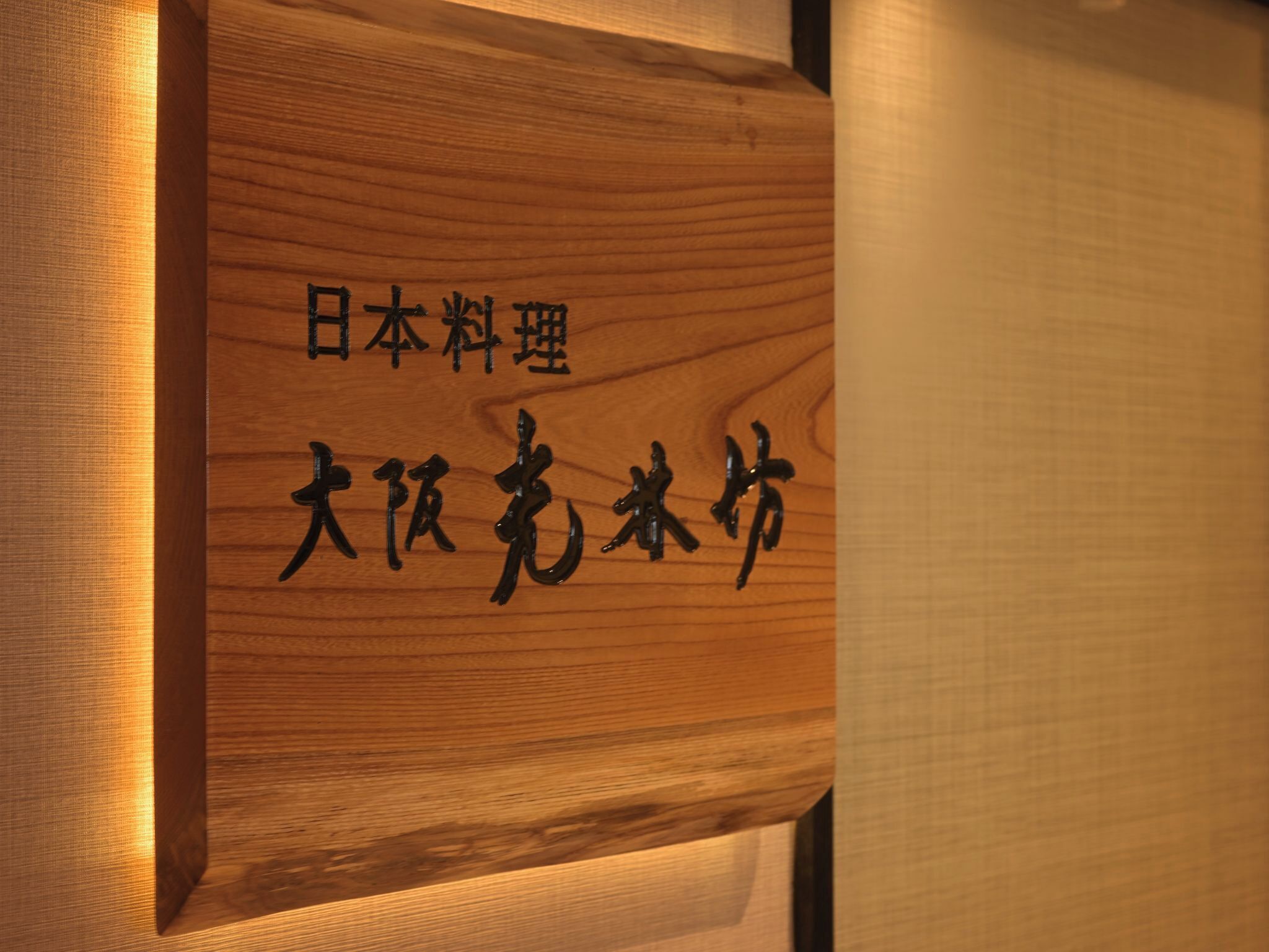 Une plaque en bois ornée de caractères japonais.