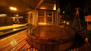 Área de hidromassagem com deck de madeira, espaço coberto para sentar e vista para o interior do edifício.