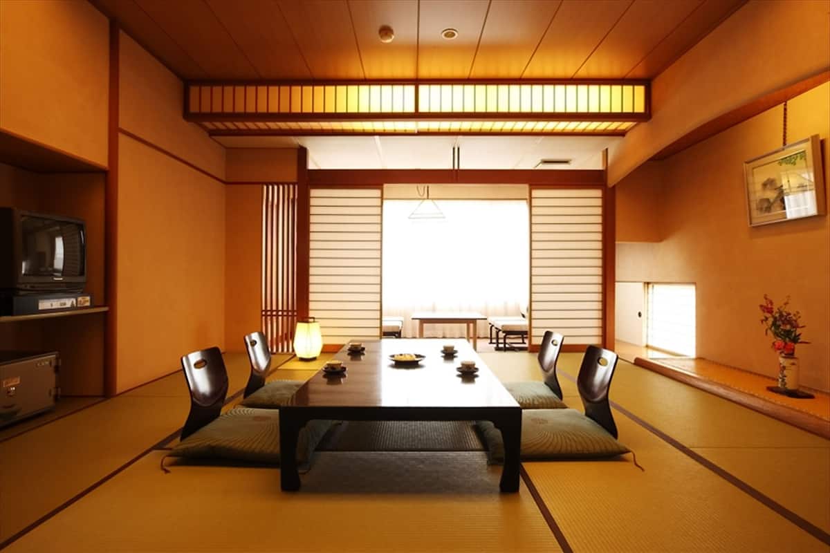 A traditional Japanese-style room with tatami flooring, a low table, and shoji screens.