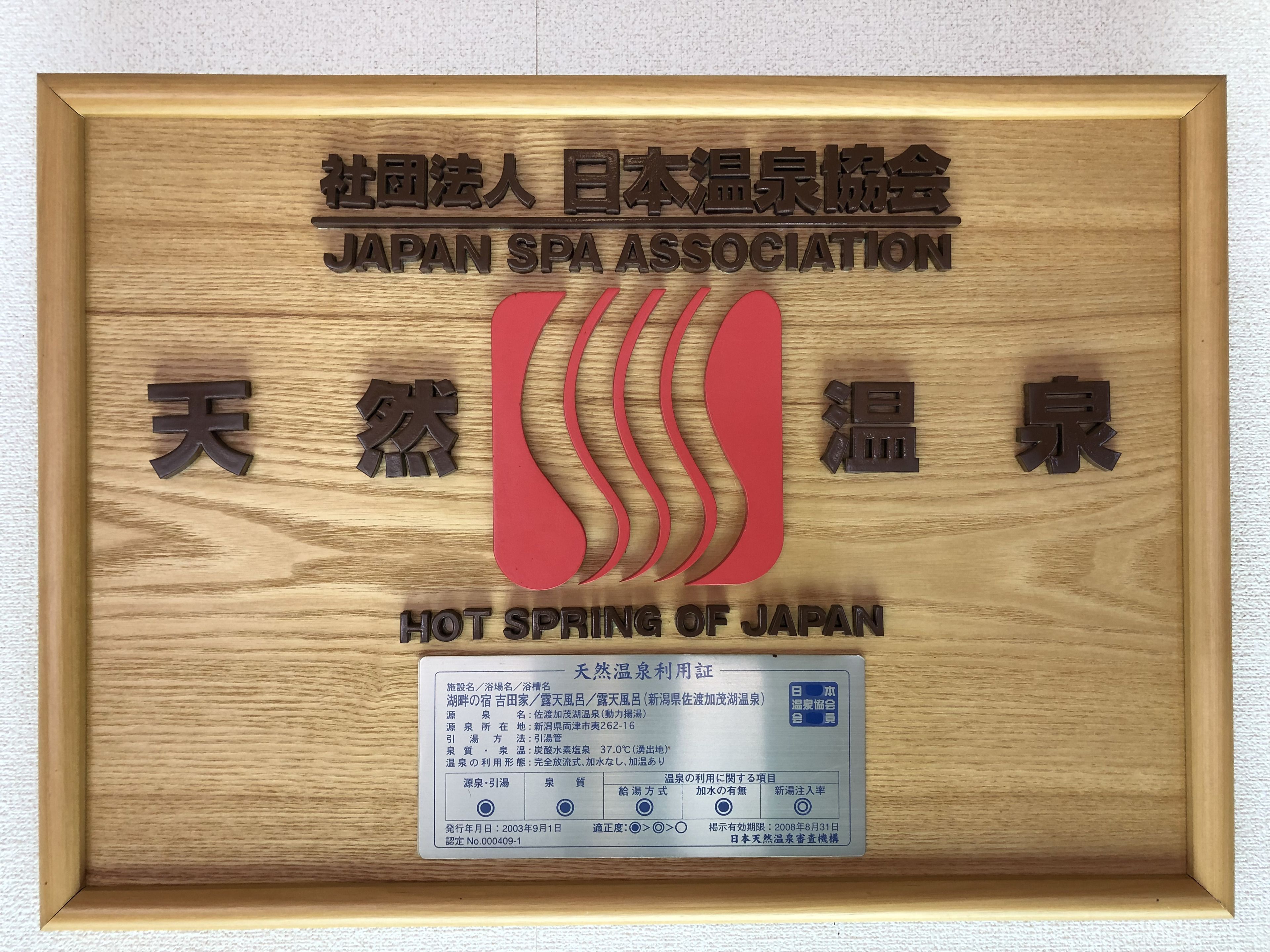 A framed sign with the Japan Spa Association logo and the text "HOT SPRING OF JAPAN".