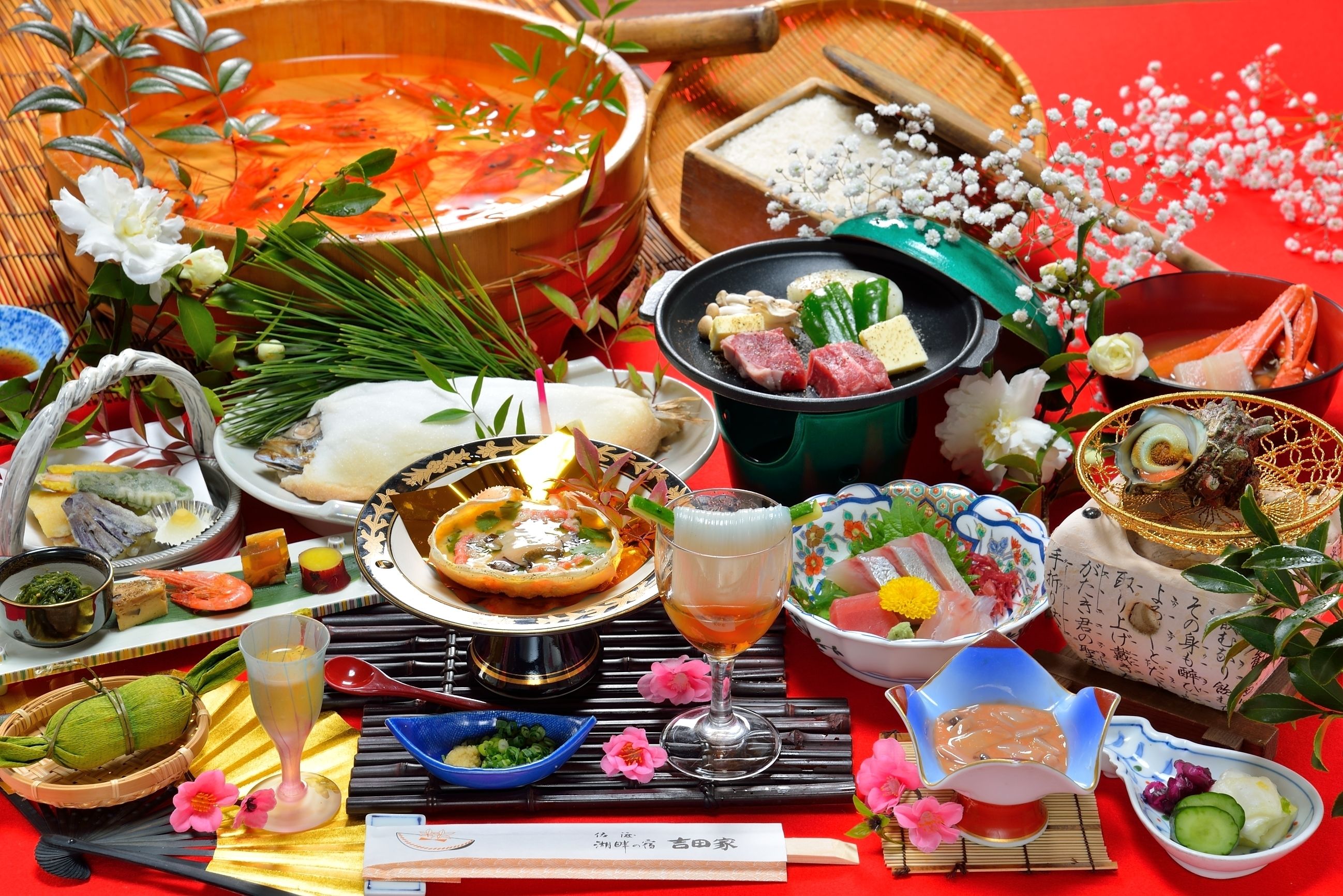 Taula ben preparada amb diferents plats, incloent una olla bullent, sashimi i una beguda.