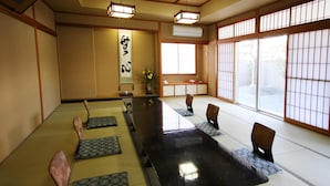 A traditional Japanese room with tatami flooring, a low table, and shoji screens. - Kohan no Yado Yoshidaya (Sado)