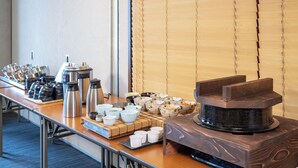Montaje tipo bufé con diversos platos y equipo para café.