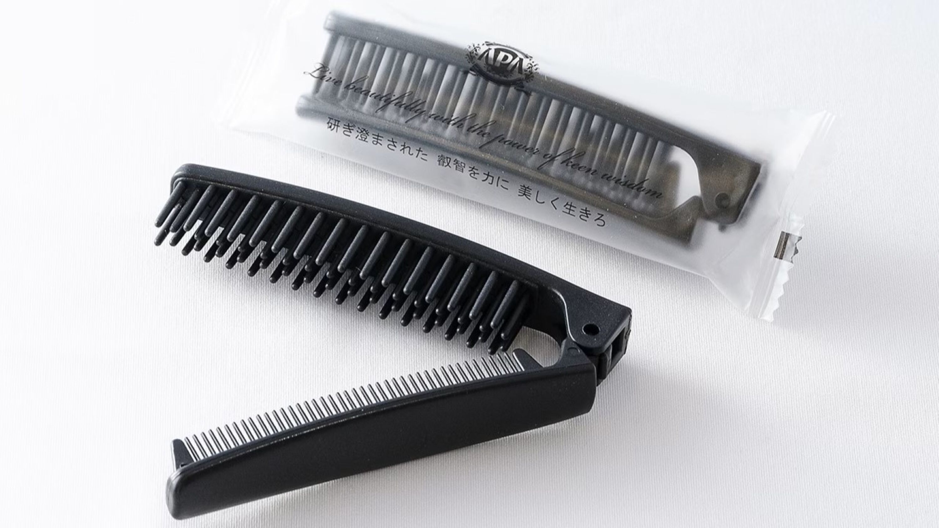 A black comb and a comb case with text on it.