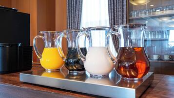 Un plateau contenant quatre carafes de différentes boissons, posé sur un comptoir en bois.