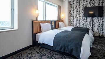 A hotel room with two beds, a TV, and a window with curtains.