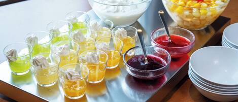 Una bandeja con diversas bebidas y un bol de ensalada de frutas.