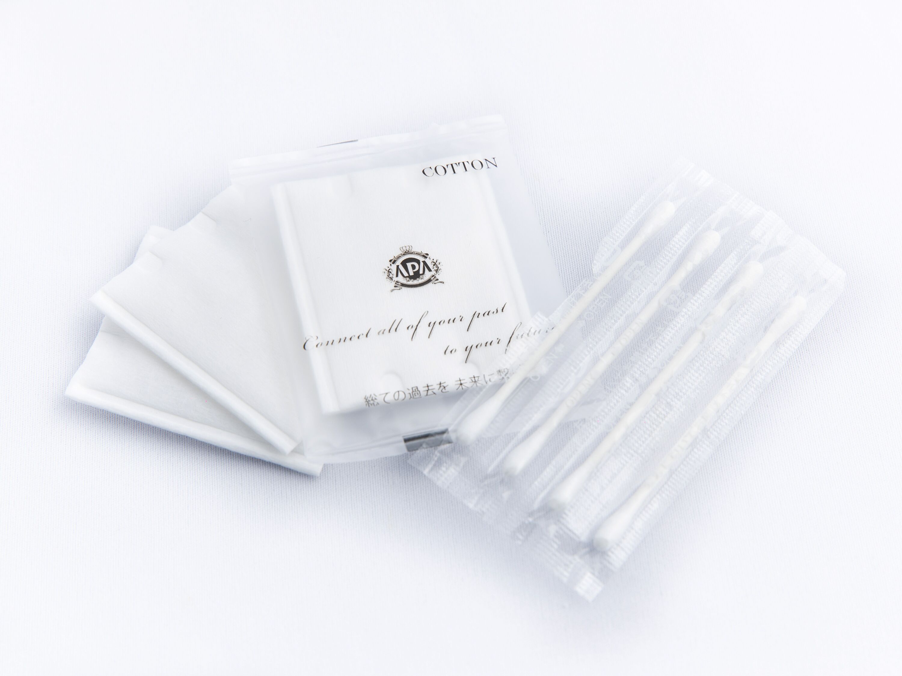 A stack of white cotton sheets with a logo and text on them.