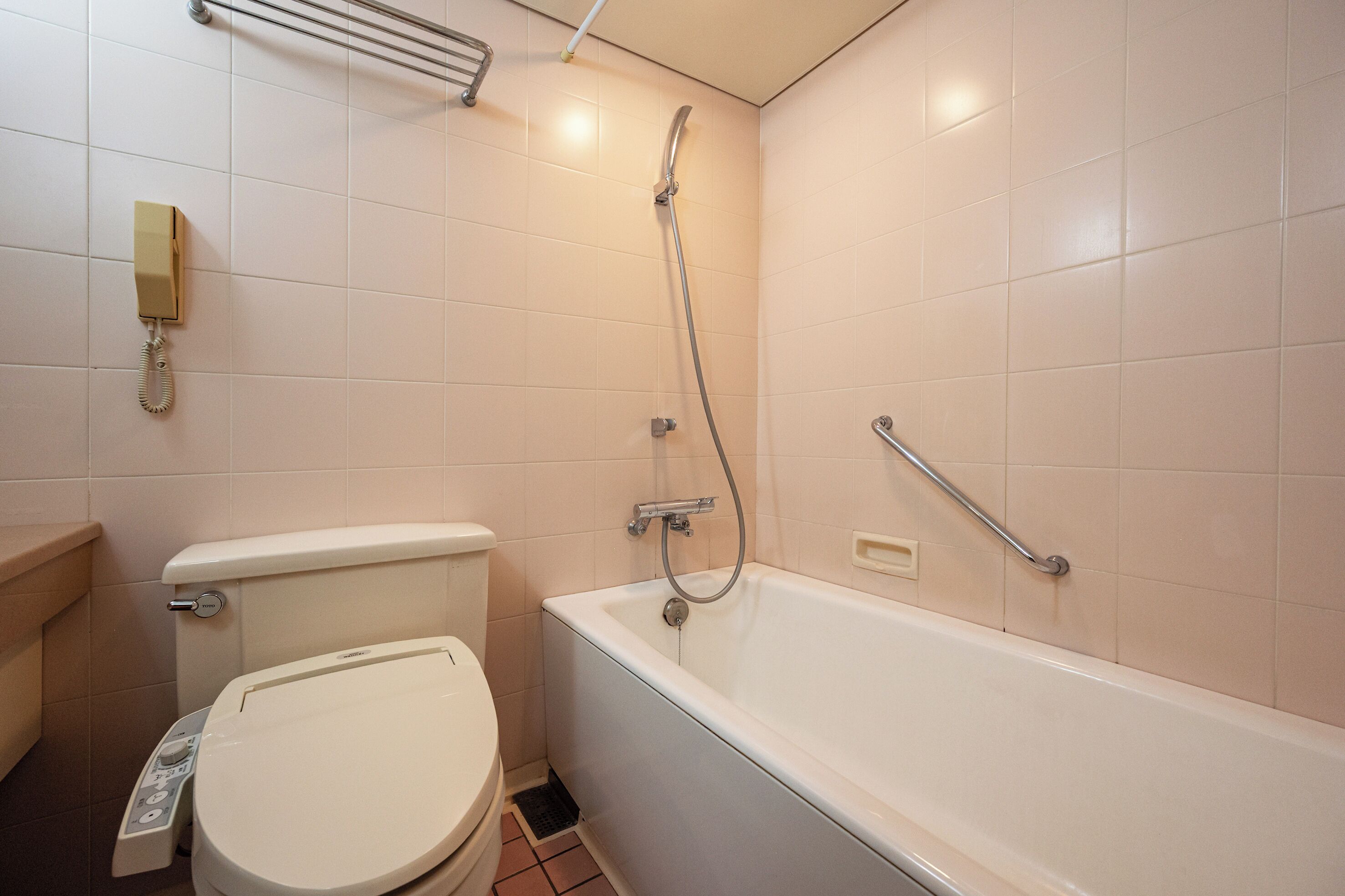 A bathroom with a toilet, a bathtub, and a shower.