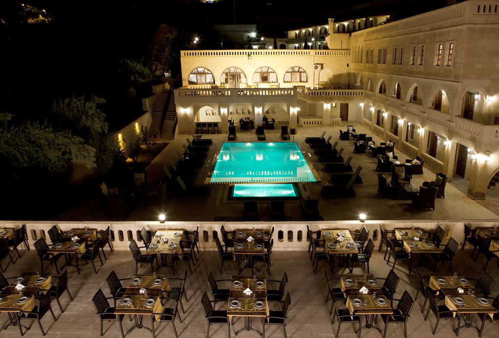 Una piscina techada, una piscina al aire libre, sombrillas