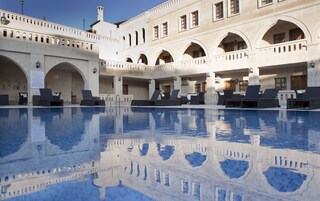 Una piscina cubierta, una piscina al aire libre, sombrillas, tumbonas