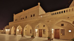 A historic building with arched walkways and multiple doors, likely a hotel or public building.