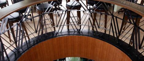 A circular interior with a central bar area, multiple seating arrangements, and a view of the outdoors through large windows.