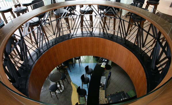 Un espacio interior circular con una zona de estar central y una escalera.