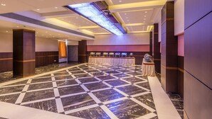 A spacious lobby with a checkered marble floor, a long reception desk, and a modern ceiling design.