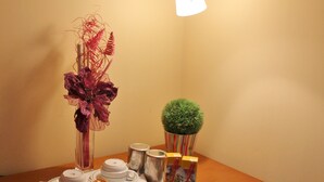 A tray with pastries, a decorative vase, and a small potted plant on a table. - Residencial Duque de Saldanha (Lisbon)