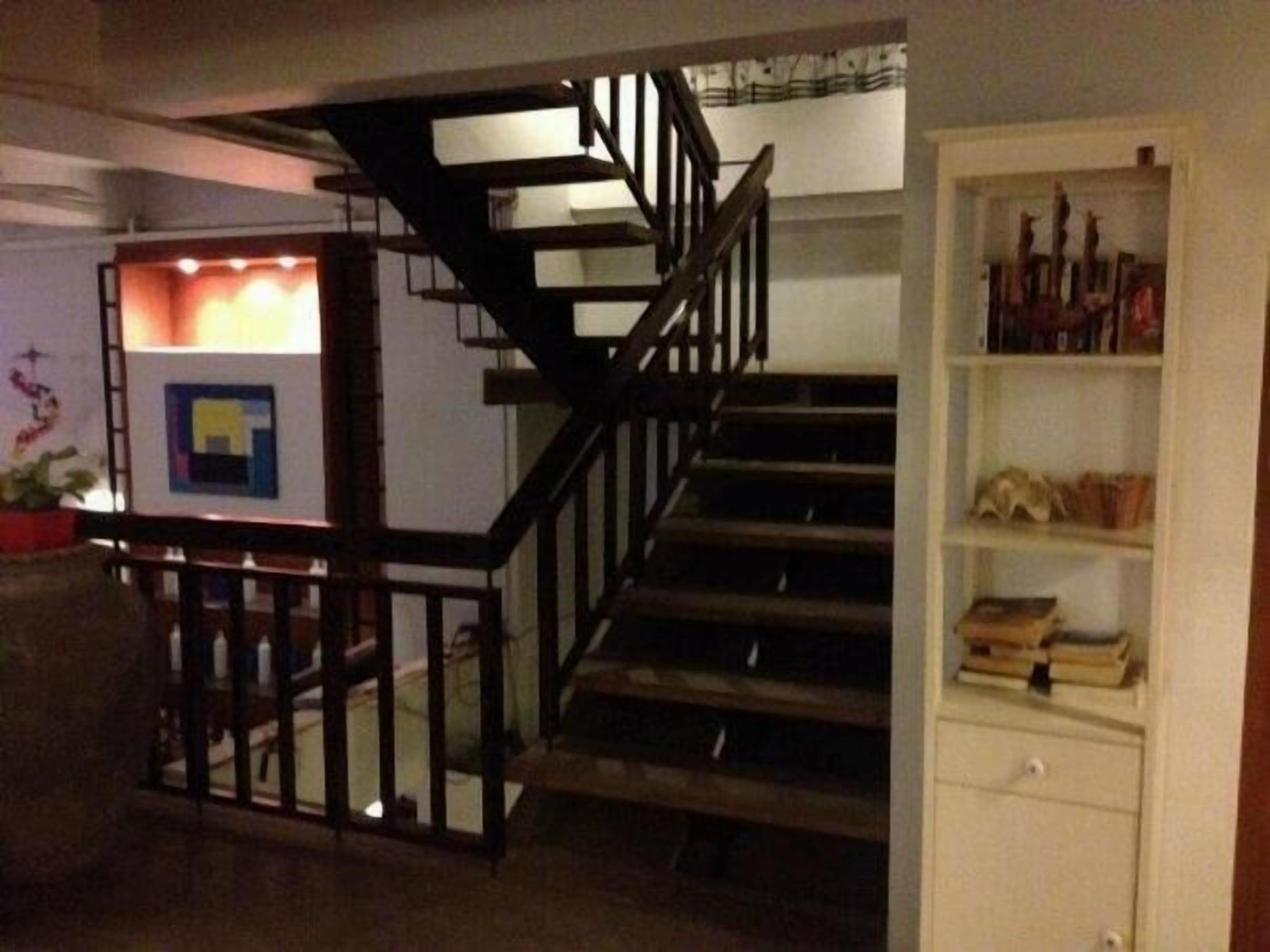 Una escalera con barandilla de madera que lleva a una plataforma.