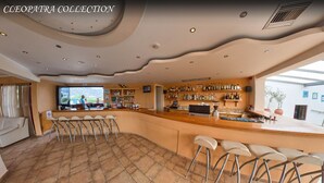 A bar area with a counter, stools, and a view of the outdoors. - Cleopatra Superior (Kos)
