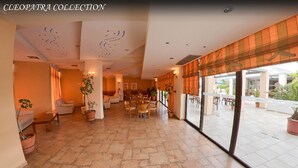 A spacious lobby with a tiled floor, comfortable seating, and large windows offering views of the outdoor area. - Cleopatra Superior (Kos)