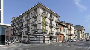 A multi-story building with a prominent 'EDEN' sign, featuring balconies and a ground-floor entrance. - Hotel Eden (Viareggio)