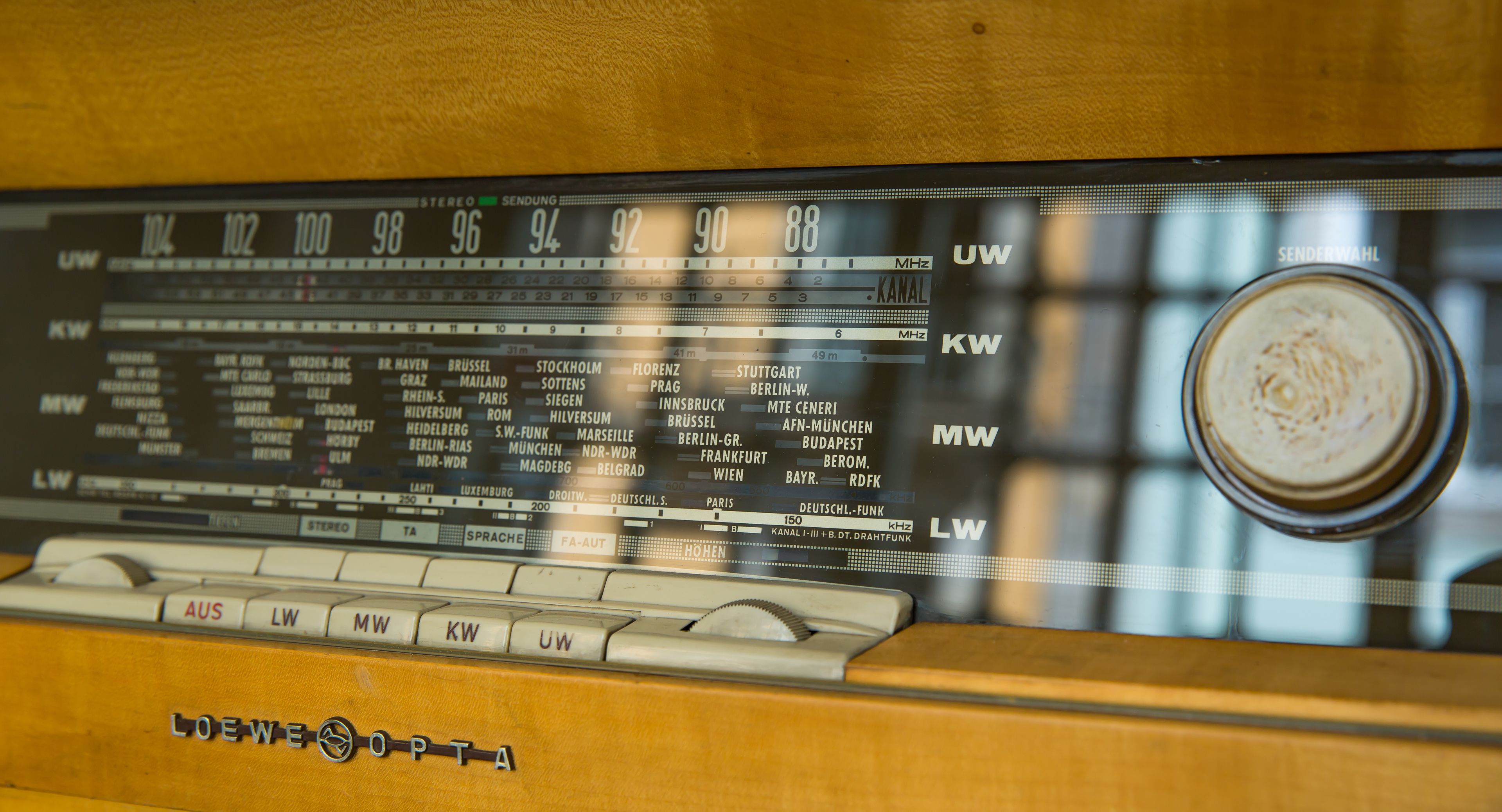 A vintage radio with frequency tuning dials and station names.