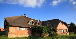 Une maison dotée d’un style architectural unique, caractérisée par un toit de chaume et des murs en pierre.