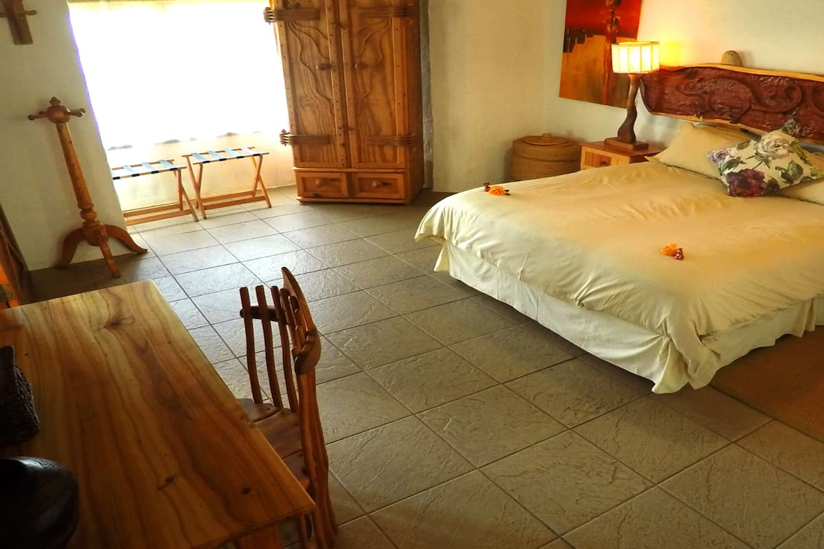Een slaapkamer met een bed, houten meubels, een nachtkastje en een lamp.