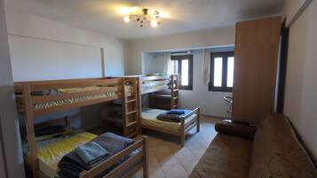 Une chambre de dortoir avec des lits superposés, un bureau et une chaise.