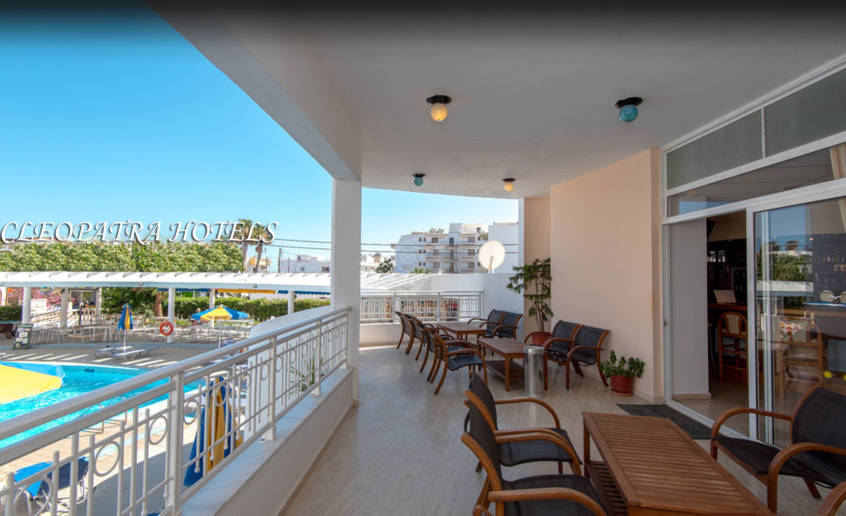A balcony with outdoor seating, a pool, and a view of Cleopatra Hotels.