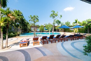 Una piscina al aire libre, tumbonas