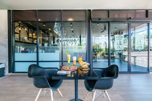 Un comedor interior con una mesa dispuesta para dos personas, que incluye comida y bebidas.
