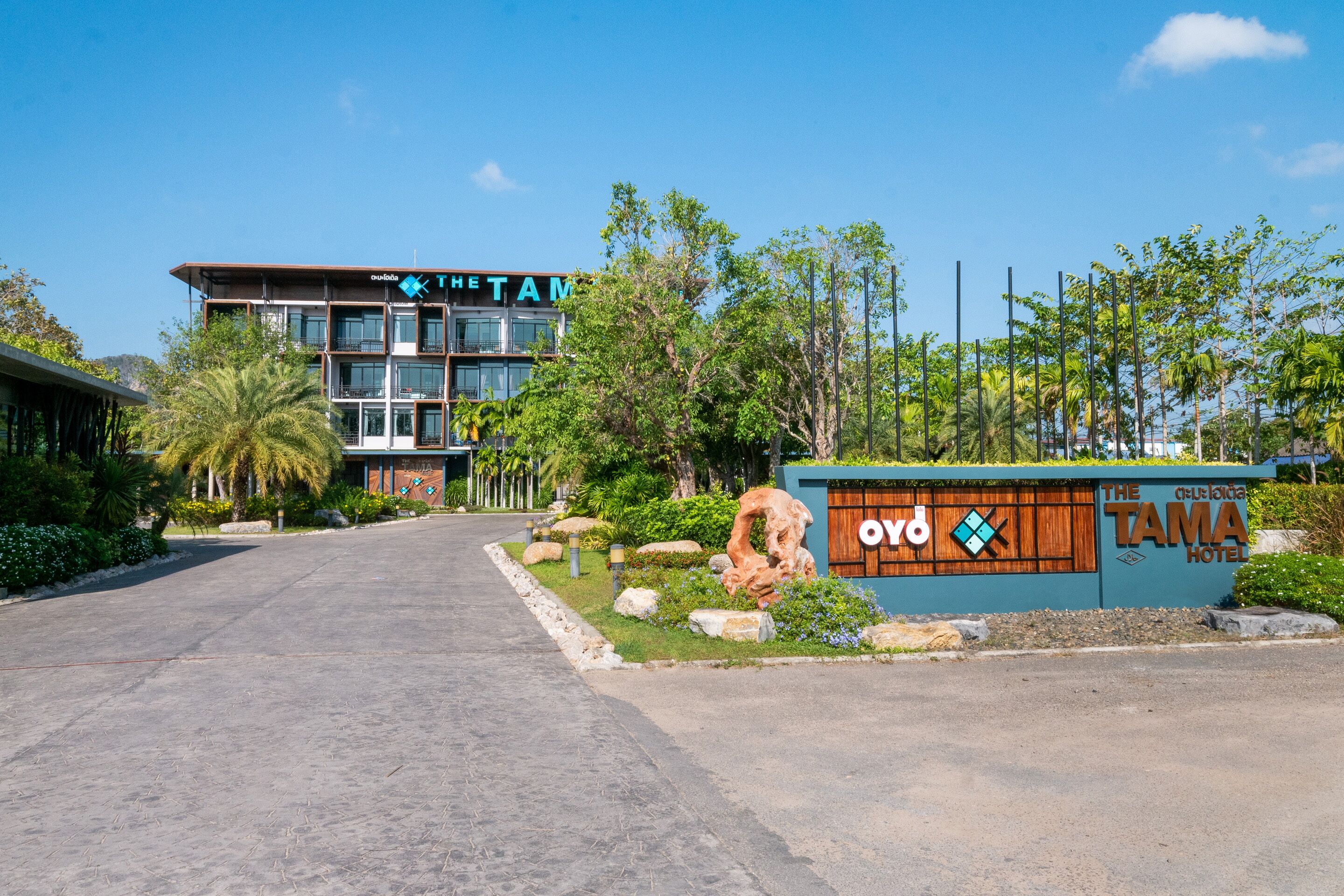 A hotel entrance with a sign reading "The Tama Hotel" and a logo.