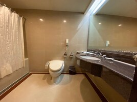 Een moderne badkamer met toilet, wastafel en spiegel.