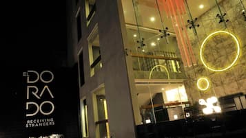 A modern building with a glass facade, illuminated by circular lights and hanging decorations.