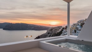 Un jacuzzi con vistas a un pueblo costero al atardecer.
