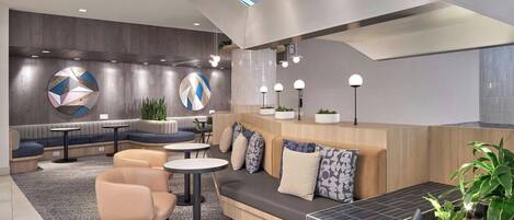 A modern lounge area with seating, tables, and decorative elements.