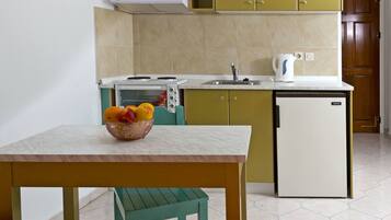 A compact kitchen with a built-in toaster, a small refrigerator, and a sink.