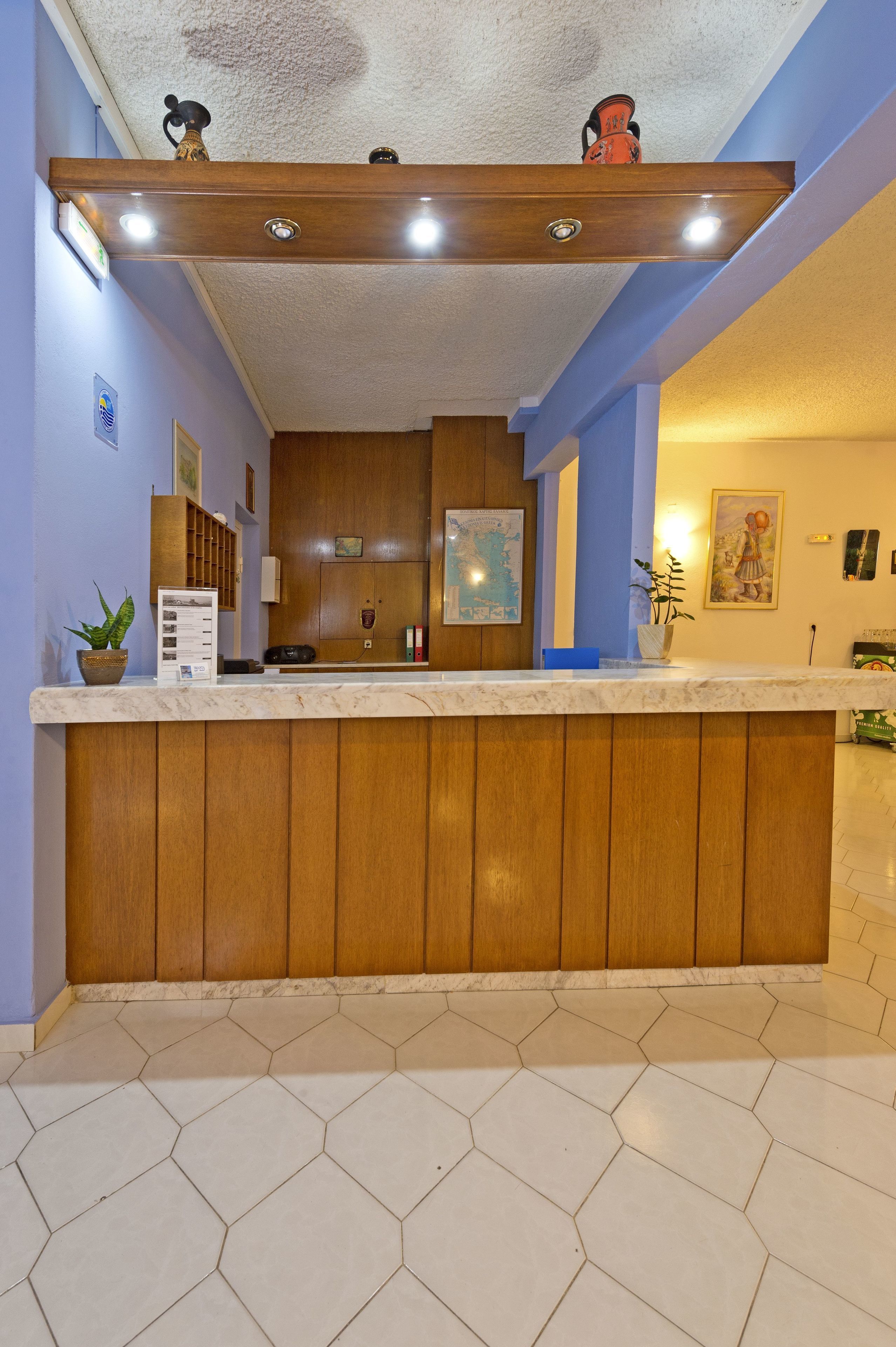 A reception area with a wooden counter, a map, and a potted plant.