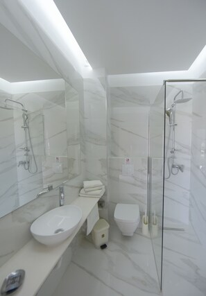 Studio | Badkamer | Een douche, een regendouche, een haardroger, handdoeken