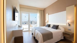 A hotel room with a large bed, a desk, a chair, and a TV. - Los Nardos (San Bartolome de Tirajana)