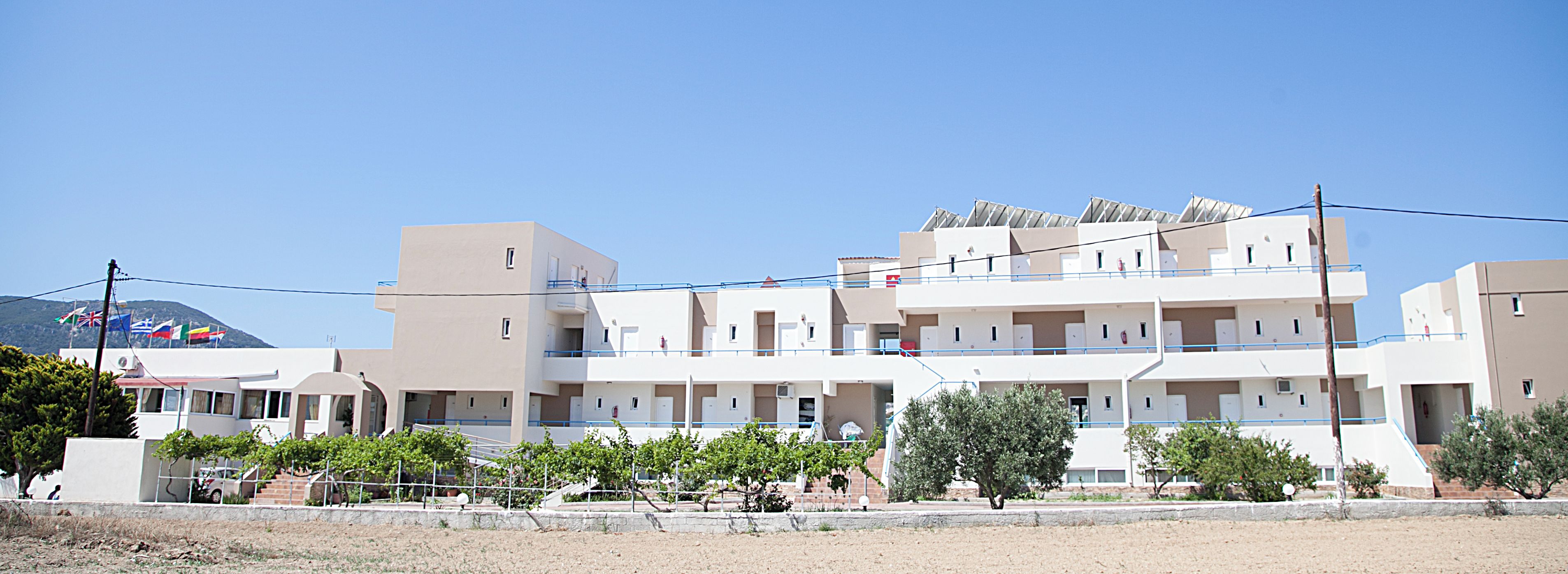 Ein mehrgeschossiges Wohngebäude mit Balkonen und blauem Himmel.