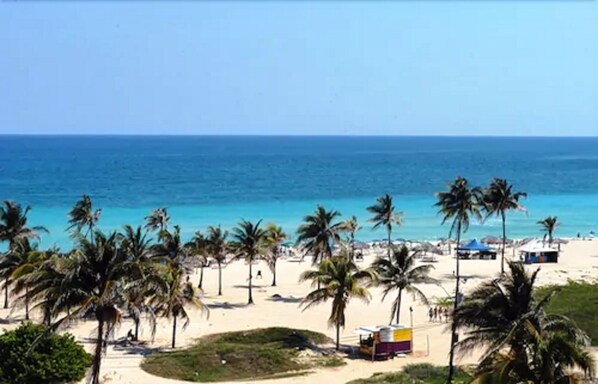 On the beach, white sand, sun loungers, beach umbrellas