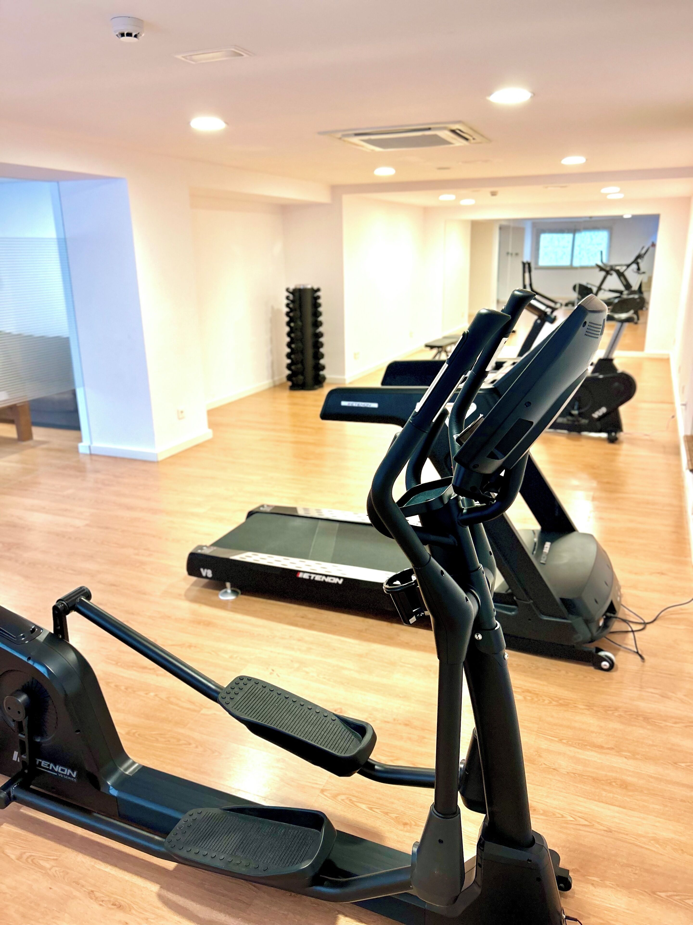 A gym with exercise equipment including treadmills and elliptical machines.