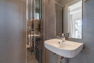 Habitación individual Deluxe | Baño | Ducha, secador de pelo y toallas