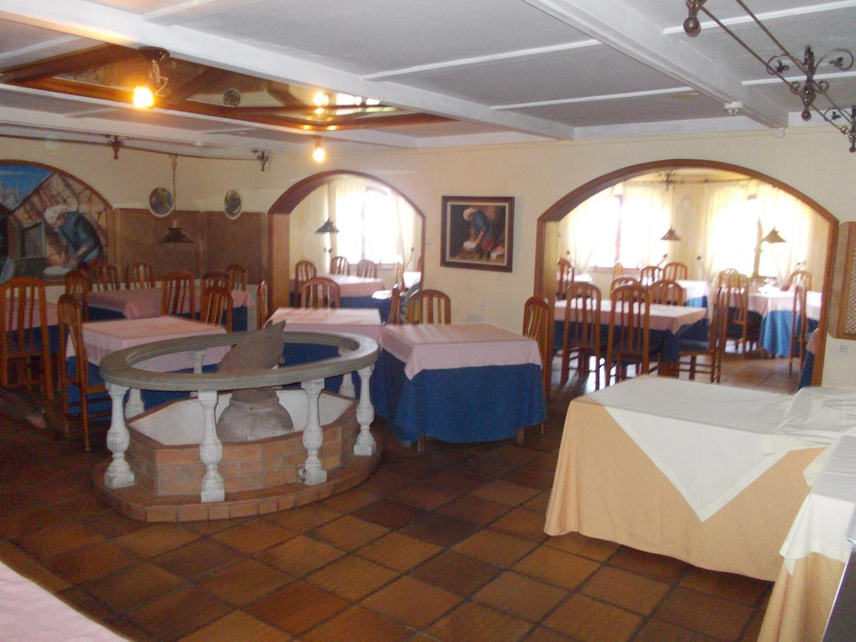 Un espace repas avec des tables rondes, des chaises et un élément décoratif central.