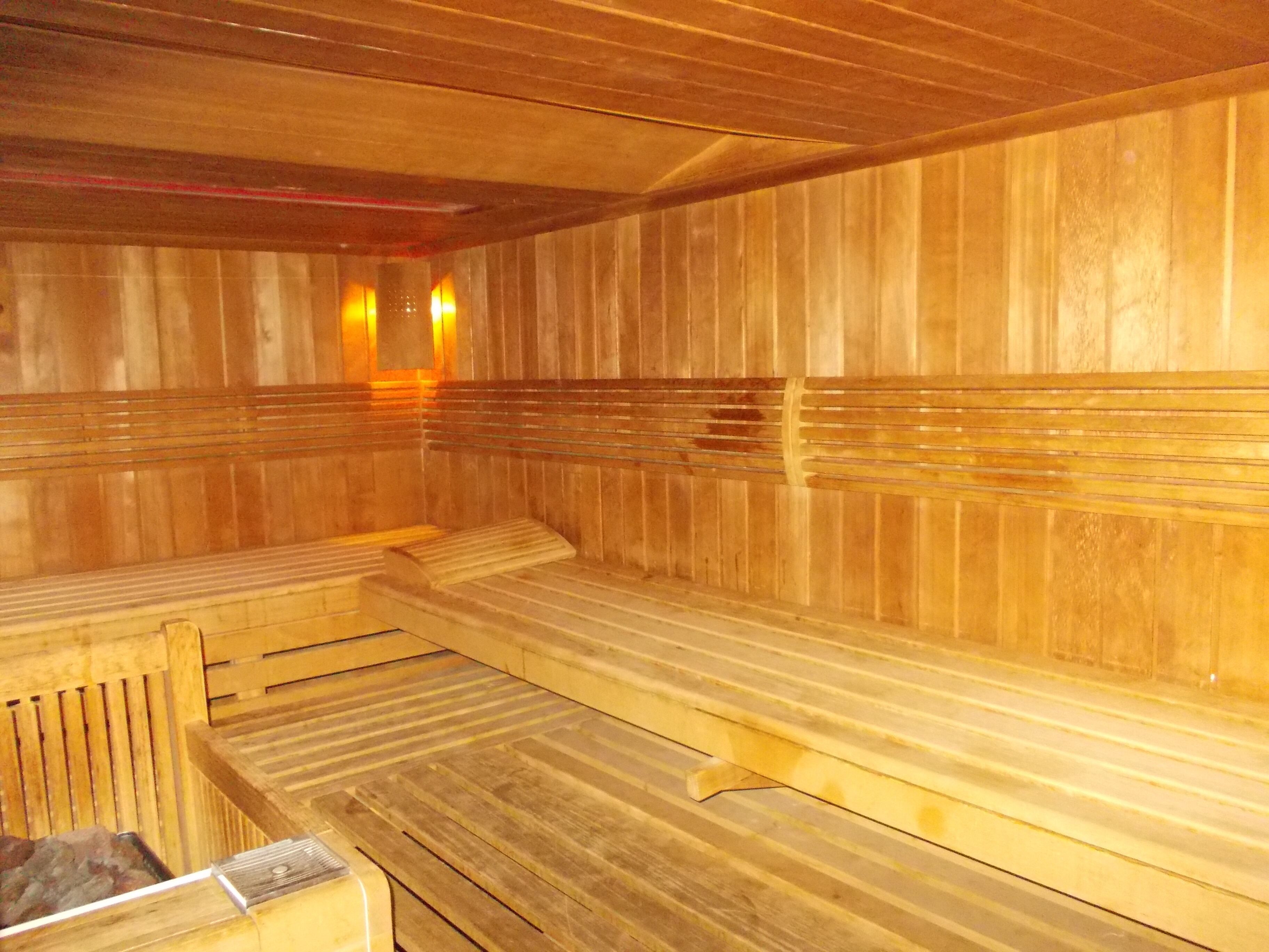 Una sauna amb seients i parets de fusta, i un banc ben visible al primer pla.