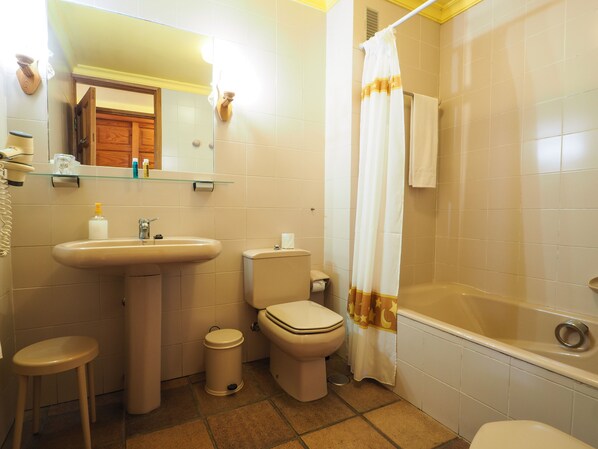 Een badkamer met een wastafel, toilet en bad.