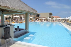 Een buitenzwembad, ligstoelen bij het zwembad