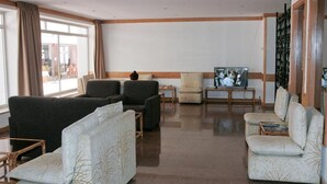 A spacious lobby with a large seating area, a television, and a view of the outside. - Atlantic Side (Silves)