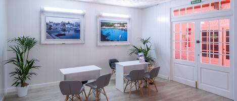 A modern room with two large windows, a white door, and a reception desk.